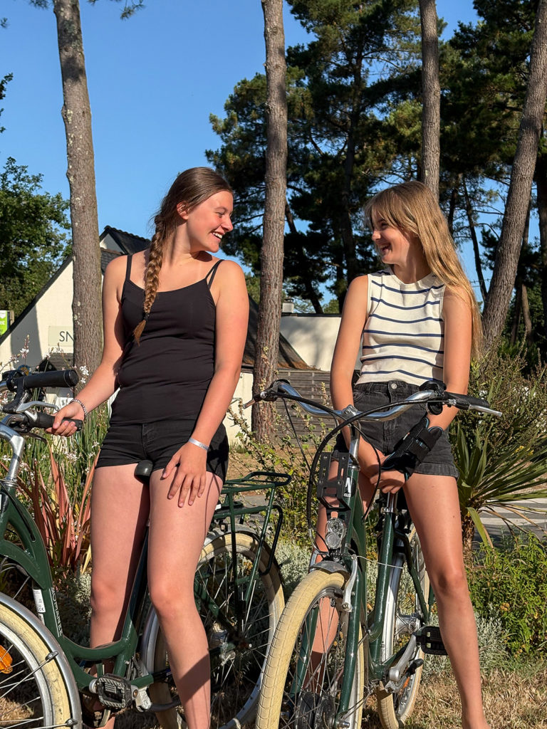 Deux personnes qui profitent du couché de soleil sur leurs vélo dans les allées du camping Le Fort Espagnol