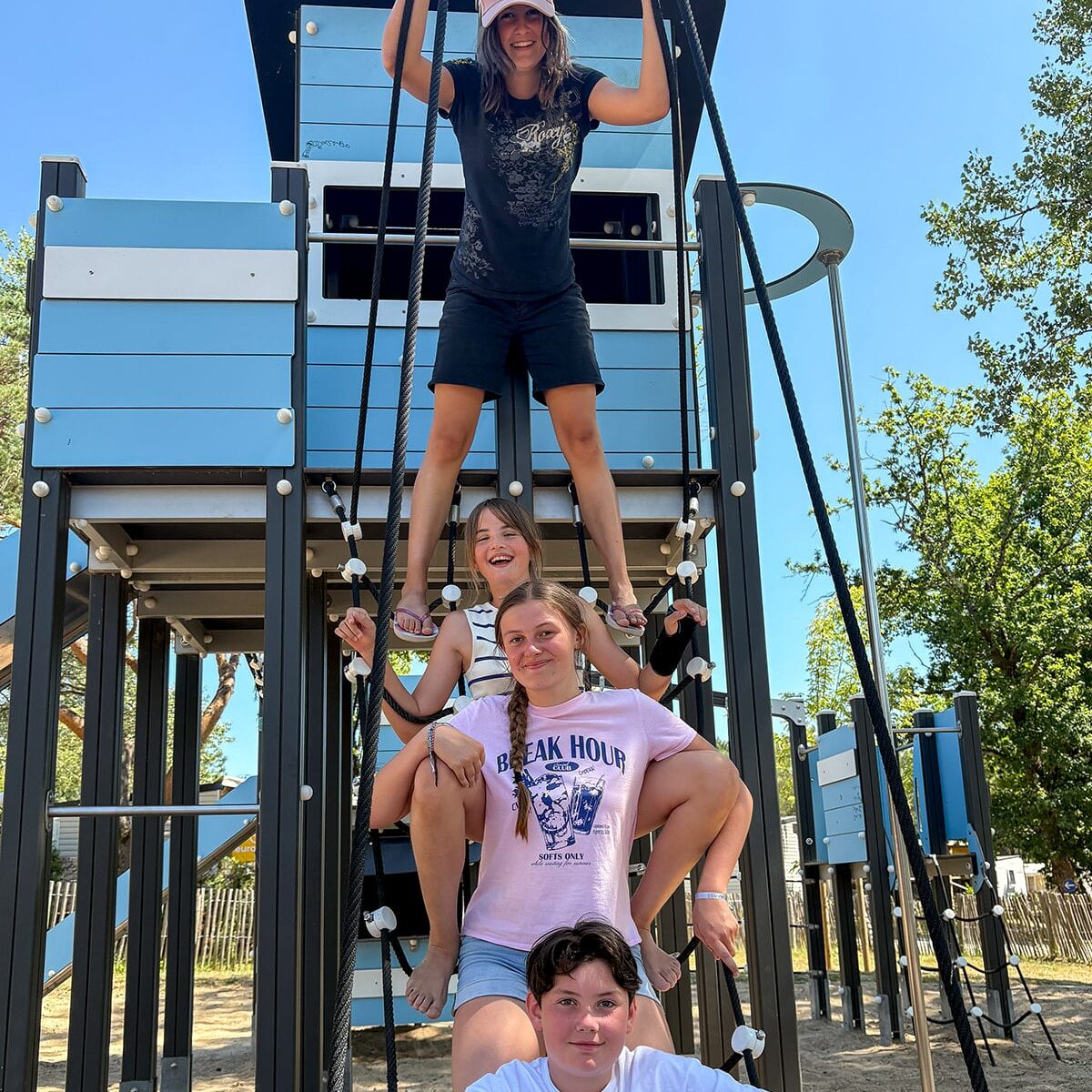 Enfants jouent sur un parcours en corde extérieure.
